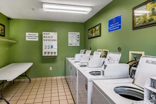 a utility room with a row of washing machines at Studio 6 Greensboro NC I40 in Greensboro