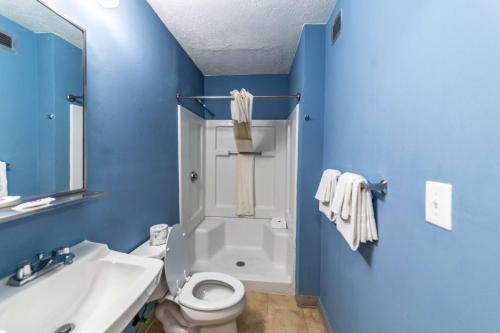 a blue bathroom with a toilet and a sink at Studio 6 Greensboro NC I40 in Greensboro