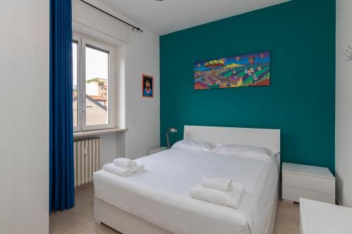 a bedroom with a white bed and a blue wall at [Luxury apartment near Navigli] Carlo D'adda 29 in Milan