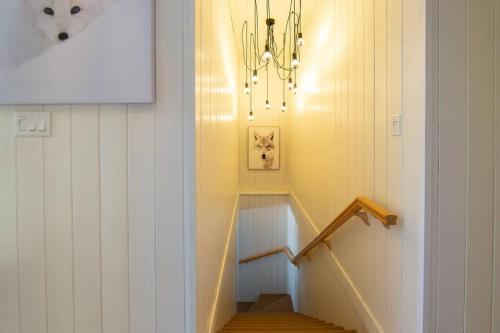 a hallway with a staircase with a chandelier at Chalet White Wolf SPA at Fiddler's Lake in Mille-Isles