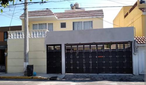 ein Haus mit einem schwarzen Tor davor in der Unterkunft Casa san jose in Chicoloapan de Juárez