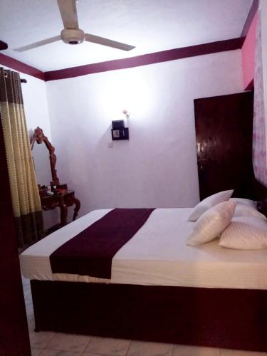 - une chambre avec un grand lit, des oreillers et un plafond dans l'établissement Chandi Mahal HomeStay, à Kandy