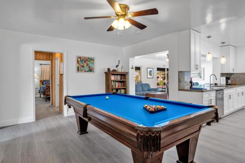 a pool table in a living room with a ceiling fan at Purely Pompano, Pool, Water front, Paddleboard, Beach, 5 bedroom 3 bath in Pompano Beach