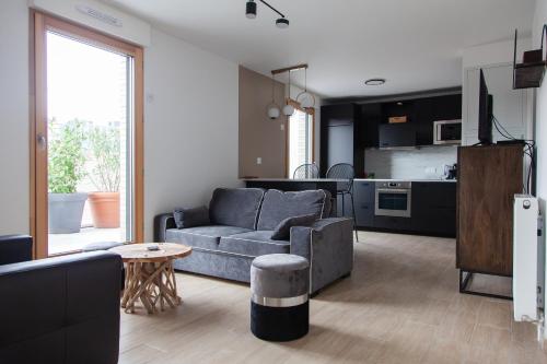 un salon avec un canapé et une cuisine dans l'établissement Appart Chic & Elégant-Métro 7 Leo-Lagrange+Parking, à Villejuif