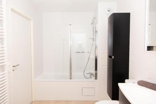 ein Bad mit einer Dusche und einer Badewanne in der Unterkunft Appart Chic & Elégant-Métro 7 Leo-Lagrange+Parking in Villejuif