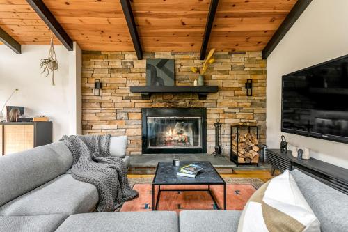 a living room with a couch and a fireplace at Woodpecker House - Mountain retreat with hot tub - 10 min to skiing in Hunter & Windham in Jewett