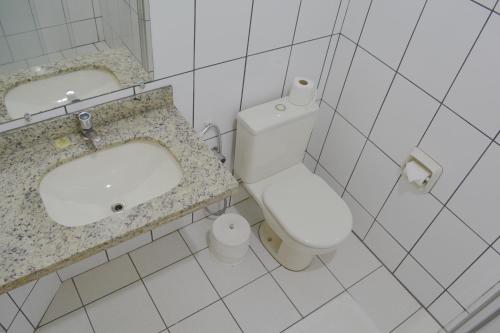 a bathroom with a white toilet and a sink at Sara Palace Hotel in Uberlândia