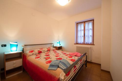 a bedroom with a bed with red flowers on it at Villa Bianca in Varenna