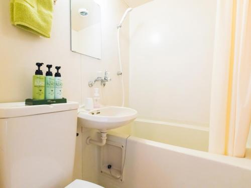 a bathroom with a sink and a toilet and a tub at SUIHOUEN in Numazu