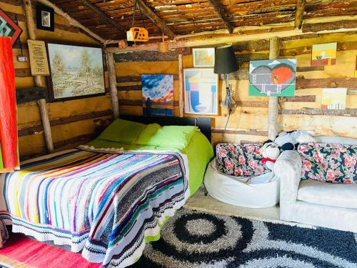 um quarto com uma cama e um sofá numa cabina em Cabaña Rústica Villa Alicia em Paipa