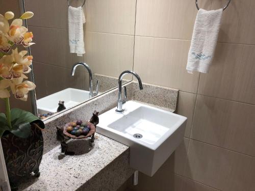 a bathroom with a sink and a mirror at LANDSCAPE - Beira mar platinum in Fortaleza