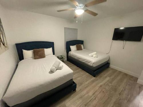 a bedroom with two beds and a flat screen tv at 7326 Lake View Bungallow-5 Minutes Universal in Orlando