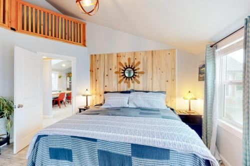 um quarto com uma cama com uma colcha azul e branca em Strandhuisje em Rockaway Beach
