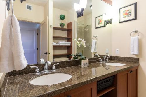 a bathroom with two sinks and a large mirror at Hali'i Kai 3B in Waikoloa