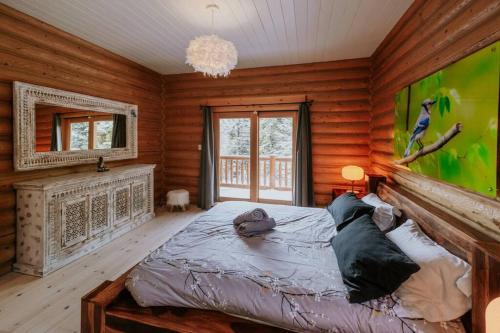 a bedroom with a bed in a room with wooden walls at Chalet Blue Jay Spa at Fiddler's Lake in Mille-Isles