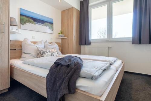 1 dormitorio con 1 cama grande en una habitación con ventanas en Strandpark-Grossenbrode-Haus-Leuchtturm-Wohnung-14-Leuchtturmblick, en Großenbrode