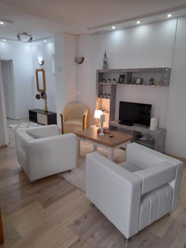 a living room with two white couches and a table at LUX Bogatić in Bogatić