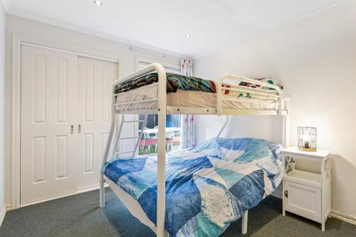 um pequeno quarto com um beliche e uma escada em The Blue Bay em Inverloch