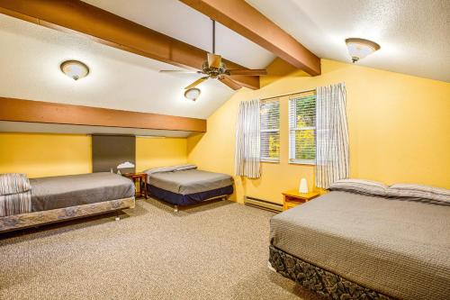 1 dormitorio con 2 camas y paredes amarillas en Peak-a-View Lakehouse, en Ronald