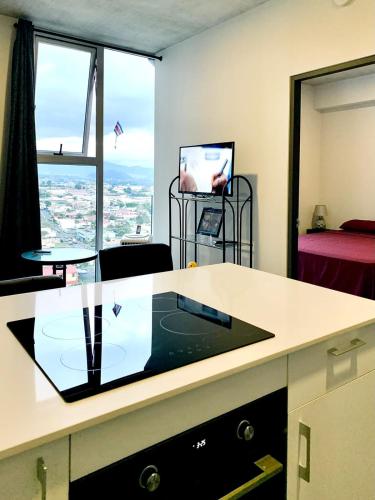 an office with a desk with a view of a room at Único Apartamento en Nuevo y Moderno Condominio in San José