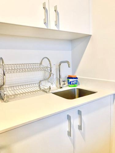 a kitchen with a sink and white cabinets at Único Apartamento en Nuevo y Moderno Condominio in San José