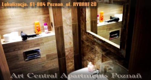 a bathroom with a mirror and a sink in it at Art Apartments in Poznań