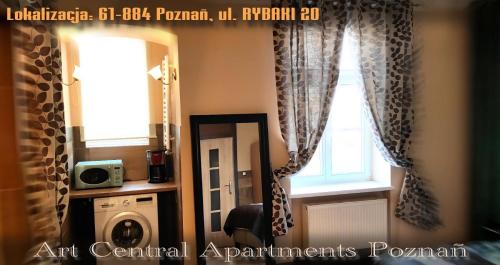 a bathroom with a mirror and a window with curtains at Art Apartments in Poznań