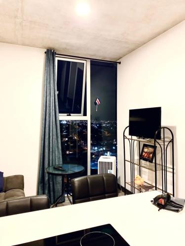 a living room with a view of a city at Único Apartamento en Nuevo y Moderno Condominio in San José