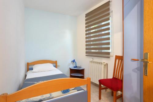 - une petite chambre avec un lit et un fauteuil rouge dans l'établissement Apartment Marina 5953b, à Marina