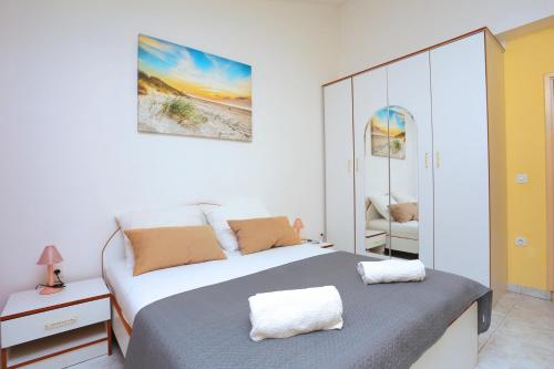 - une chambre blanche avec un lit et un miroir dans l'établissement Apartment Marina 5953c, à Marina