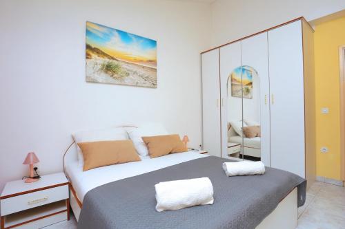 Un dormitorio blanco con una cama y un espejo. en Apartment Marina 5953c, en Marina