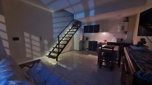 una sala de estar con una escalera que conduce a una cocina en Departamento Libertad en Tandil