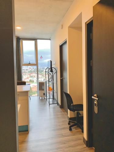 a room with a desk and a chair and a window at Único Apartamento en Nuevo y Moderno Condominio in San José