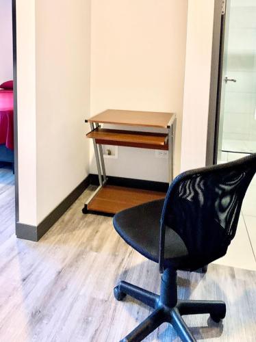 a black office chair sitting in front of a desk at Único Apartamento en Nuevo y Moderno Condominio in San José