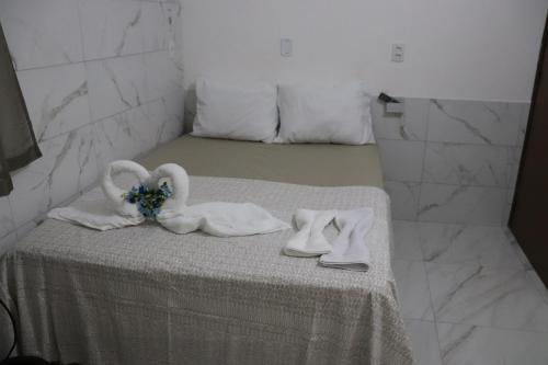 een tafel met twee zwanen, handdoeken en schoenen erop bij Suítes Mar de Maragogi in Maragogi