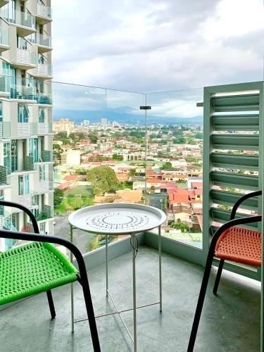 a table and chairs on a balcony with a view at Único Apartamento en Nuevo y Moderno Condominio in San José