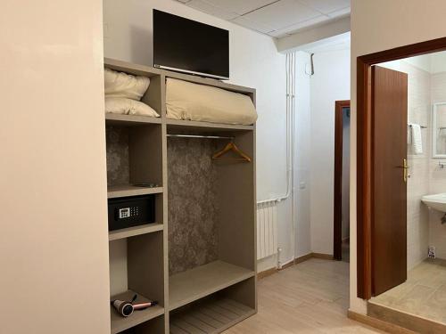 Habitación con armario y TV en la pared. en Hotel principe en Roma