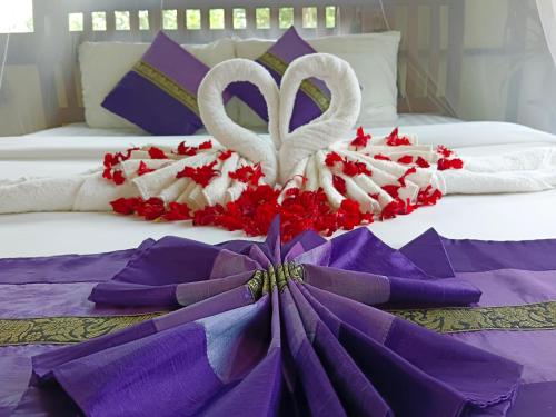 a bed with two hearts and flowers on it at Khao Sok River & Jungle Bungalow in Khao Sok