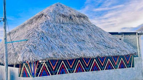 a hut with a thatched roof on top of it at Estrella de mar in Cabo de la Vela
