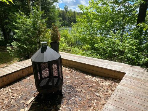 a black lamp sitting on top of a wooden deck at Chalet Kabana Spa au bord du lac in Sainte-Émélie-de-lʼÉnergie