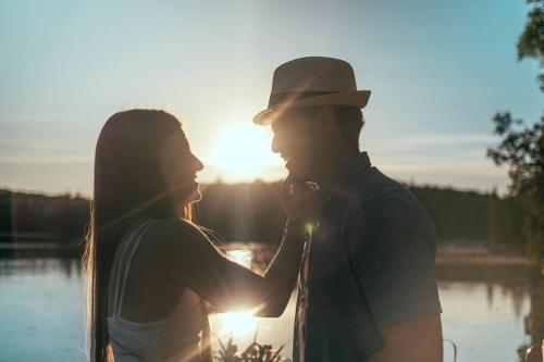 a man and a woman standing in front of the sun at Chalet Kabana Spa au bord du lac in Sainte-Émélie-de-lʼÉnergie