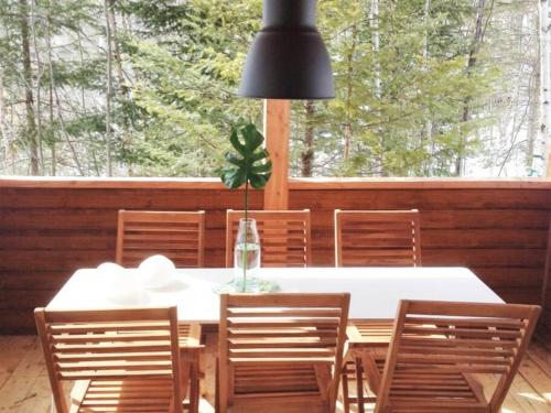 a dining room with a white table and chairs at Chalet Kabana Spa au bord du lac in Sainte-Émélie-de-lʼÉnergie