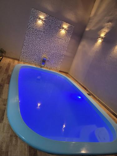 El baño incluye una gran bañera azul con luces. en Recanto Dimarco com Piscina!, en Olímpia