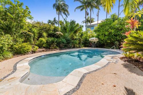 a swimming pool in a yard with palm trees at 1 Aarons Villa in Noosaville