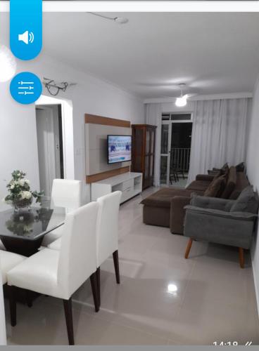 a living room with a couch and a table at Apartamento pé na areia in Guarujá