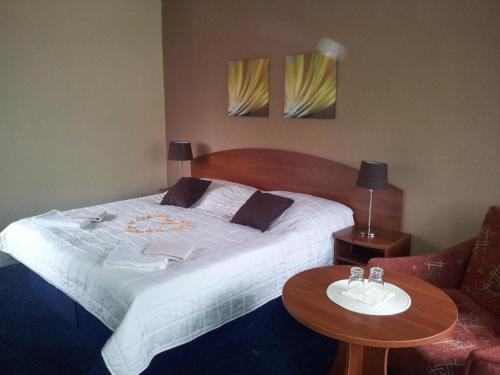 a bedroom with a large bed and a table at Hotel Centrum Harrachov in Harrachov
