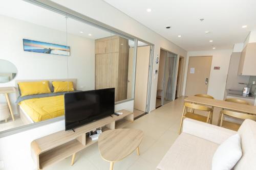a living room with a bed and a television at The Song Luxury Condotel Vung Tau - Căn hộ cao cấp Luca's House in Vung Tau