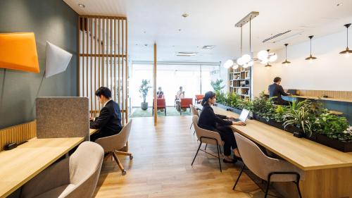 a group of people sitting at tables in a lobby at JR-East Hotel Mets Omori in Tokyo