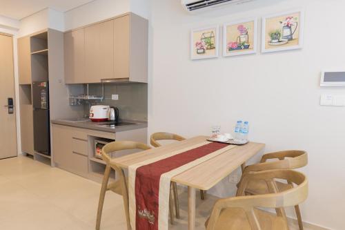 a kitchen with a wooden table and chairs at The Song Luxury Condotel Vung Tau - Căn hộ cao cấp Luca's House in Vung Tau