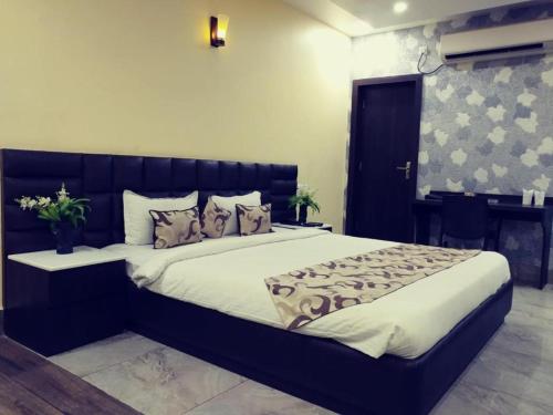 una camera con un grande letto con testiera nera di Hotel Madhuvan by TravelkartOnline a Dhanbād